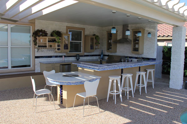 the finished outdoor kitchen features a bar